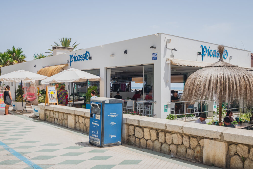 Hamacas y sombrillas en Chiringuito Picasso en la playa de La Malagueta, Málaga, con el mar de fondo