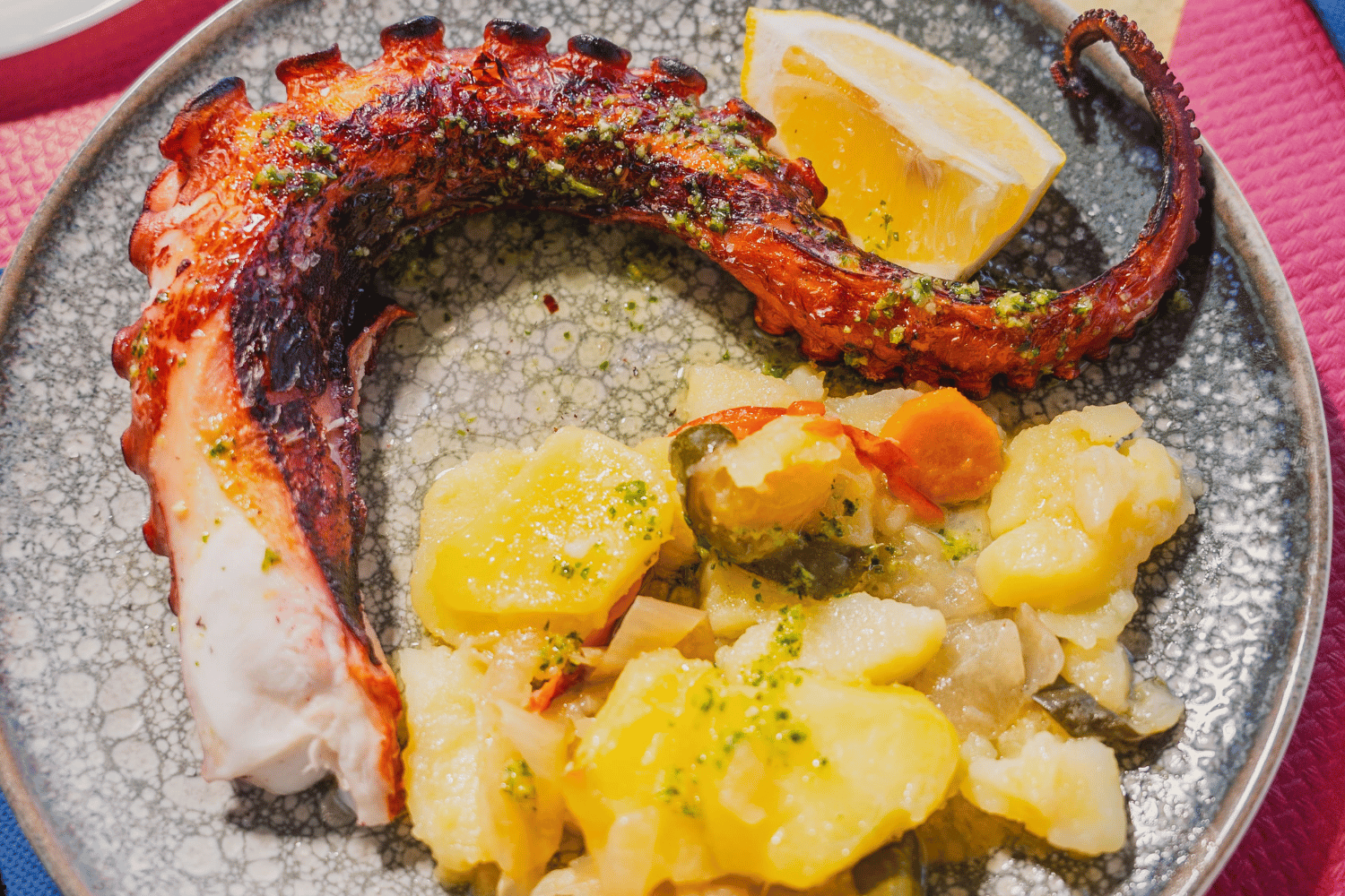 Primer plano de espetos de sardinas y plato de pescaíto frito en una mesa de Chiringuito Picasso en Málaga