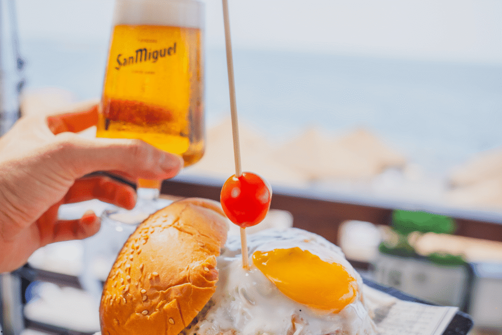 Vista nocturna de una fiesta en la terraza de Chiringuito Picasso con luces, música y gente celebrando junto a la playa en Málaga