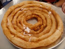 Churros tejeringos servidos con chocolate caliente frente al mar en la playa de la Malagueta